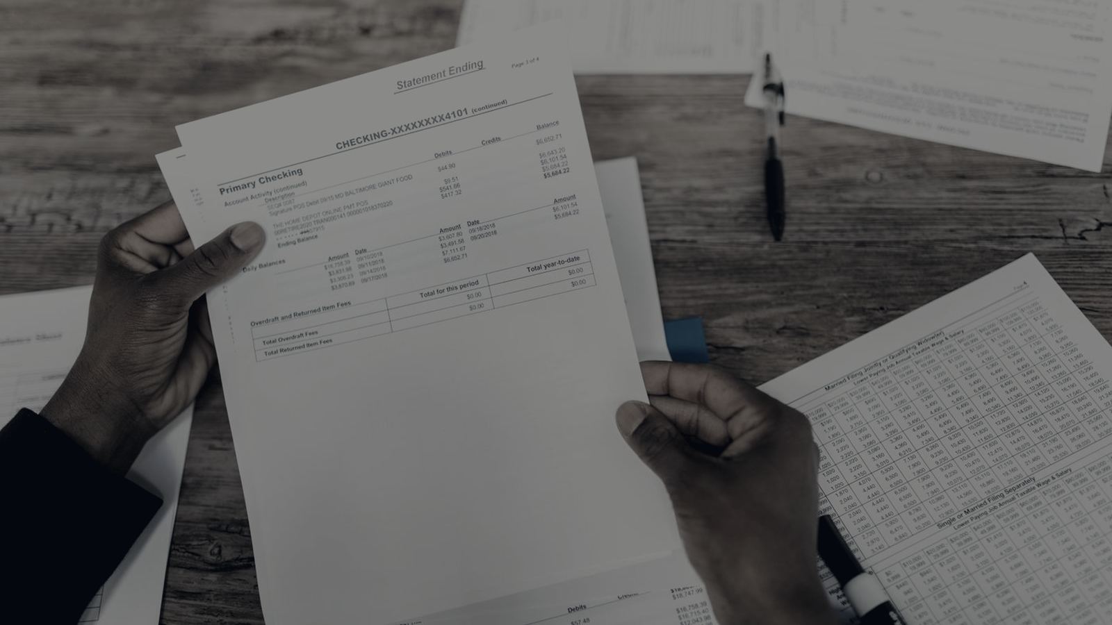 Overhead view of financial statements and working papers being reviewed at a desk